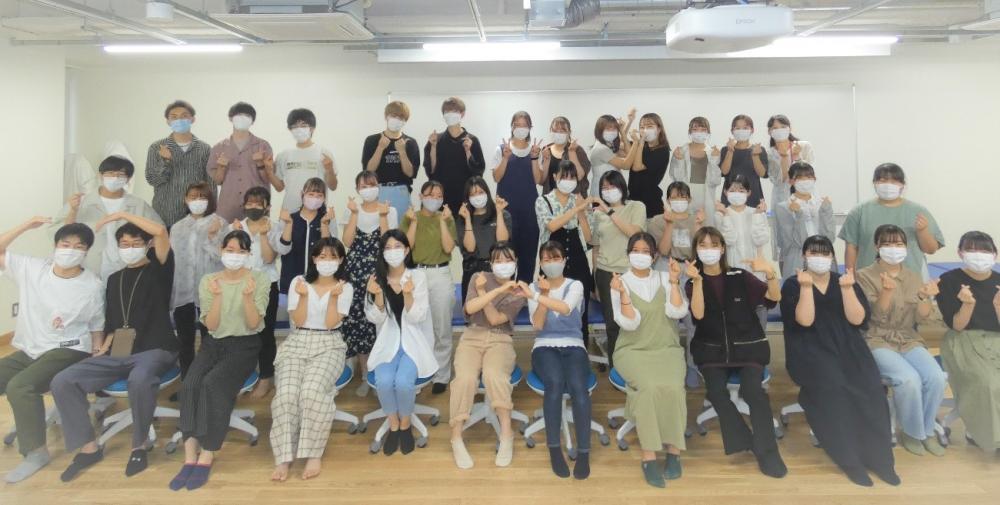 作業療法学科の学生たちがマスクを着用し、ポーズを決めて笑顔で集合している写真。