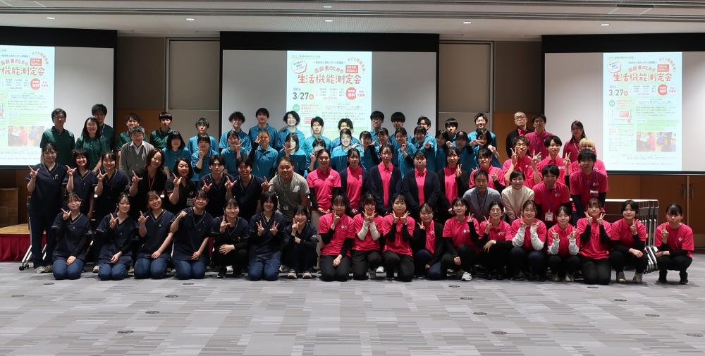 福島県立医科大学で開催された高齢者のための生活機能測定会の集合写真。教員と学生が参加し、コロナ禍明けの活動を祝う様子。