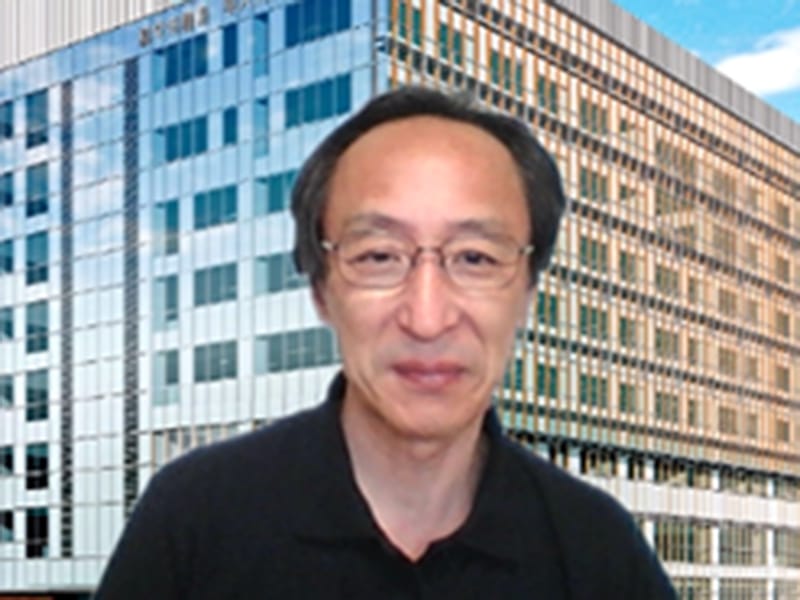 福島県立医科大学の背景に立つ男性のポートレート。