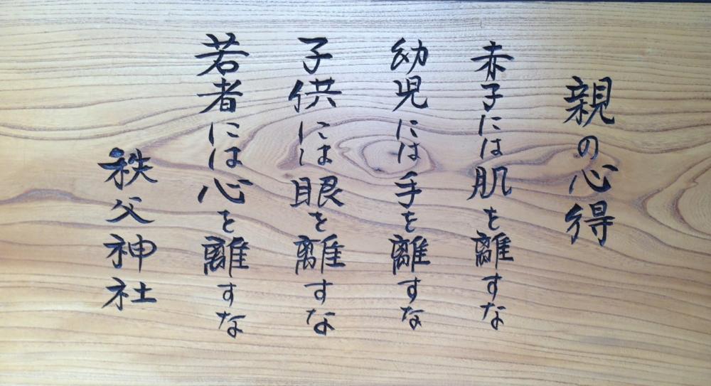 親の心得を示す看板が写っている写真。秩父神社での子育てに関するメッセージが刻まれている。