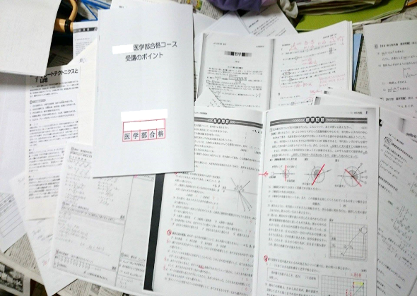 家庭教師時代の教材やノートが散らばった机の上の様子。勉強に対する全力投球の痕跡。