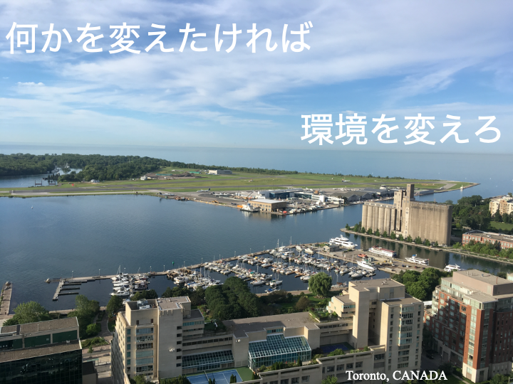 トロントの港と緑豊かな島が見える風景、上部には「何かを変えたければ環境を変えろ」とのメッセージ。