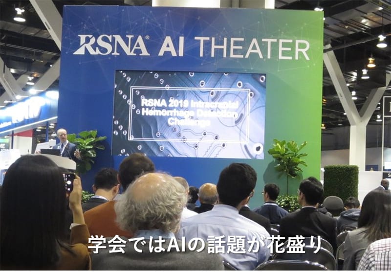 AIに関する学会での講演風景。参加者が集まり、AI技術の進展について議論している様子。