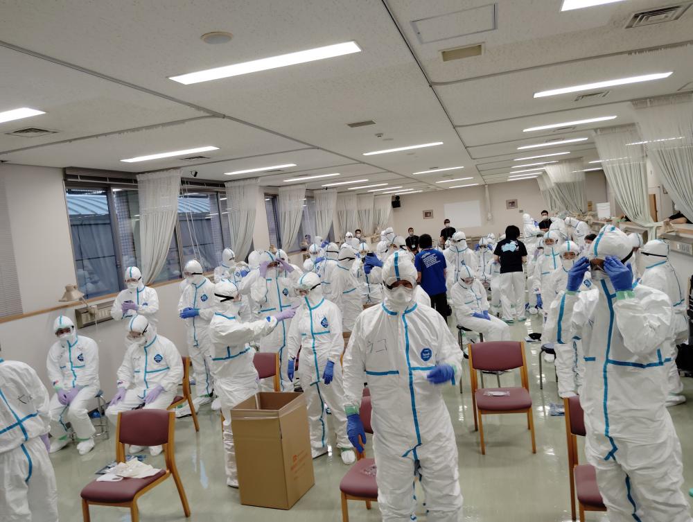 CBRNE研修に参加するスタッフが防護服を着用し、訓練を受けている様子。