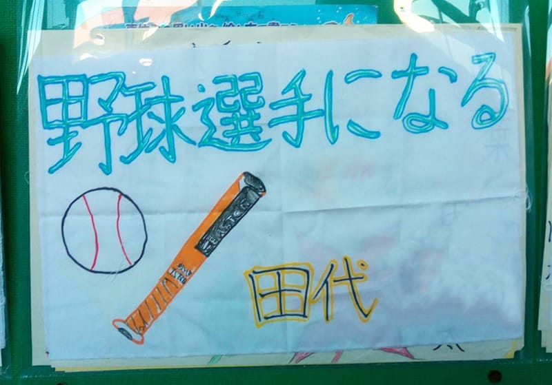 野球選手になると書かれた手書きの掲示物と野球のボール、バットのイラスト。