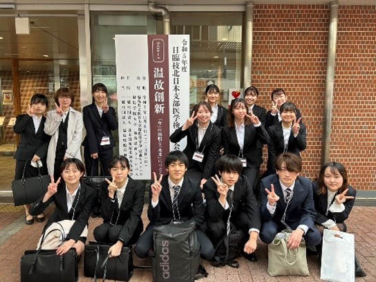 第11回日臨技北日本支部医学検査学会に参加した学生たちが、笑顔でポーズをとっている写真。