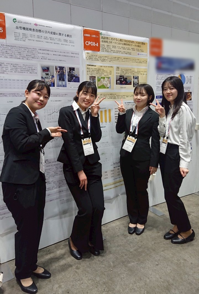 臨床検査学科の3年生4名が学会でポスター発表を行い、笑顔でポーズをとっている様子。
