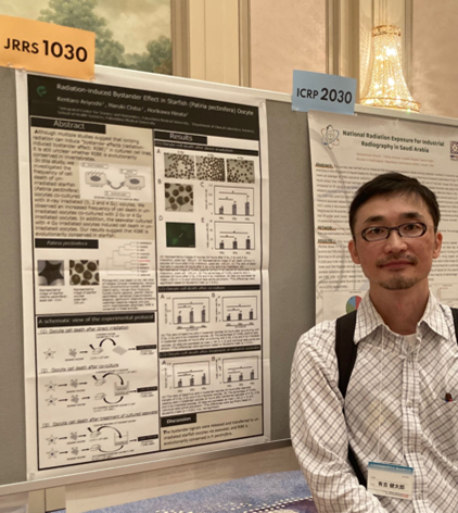 臨床検査学科の学生と共同研究の成果を発表するため、学会でポスターの前に立つ男性。