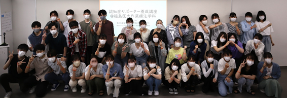認知症サポーター養成講座に参加した学生たちが集合し、マスクを着用してポーズをとっている様子。
