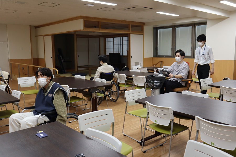 福祉用具の体験会で、車椅子を使用する参加者やスタッフがいる室内の様子。
