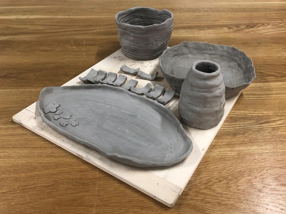 認知症サポーター養成講座で作成された陶芸作品の写真。灰色の陶器が数点並んでいる。