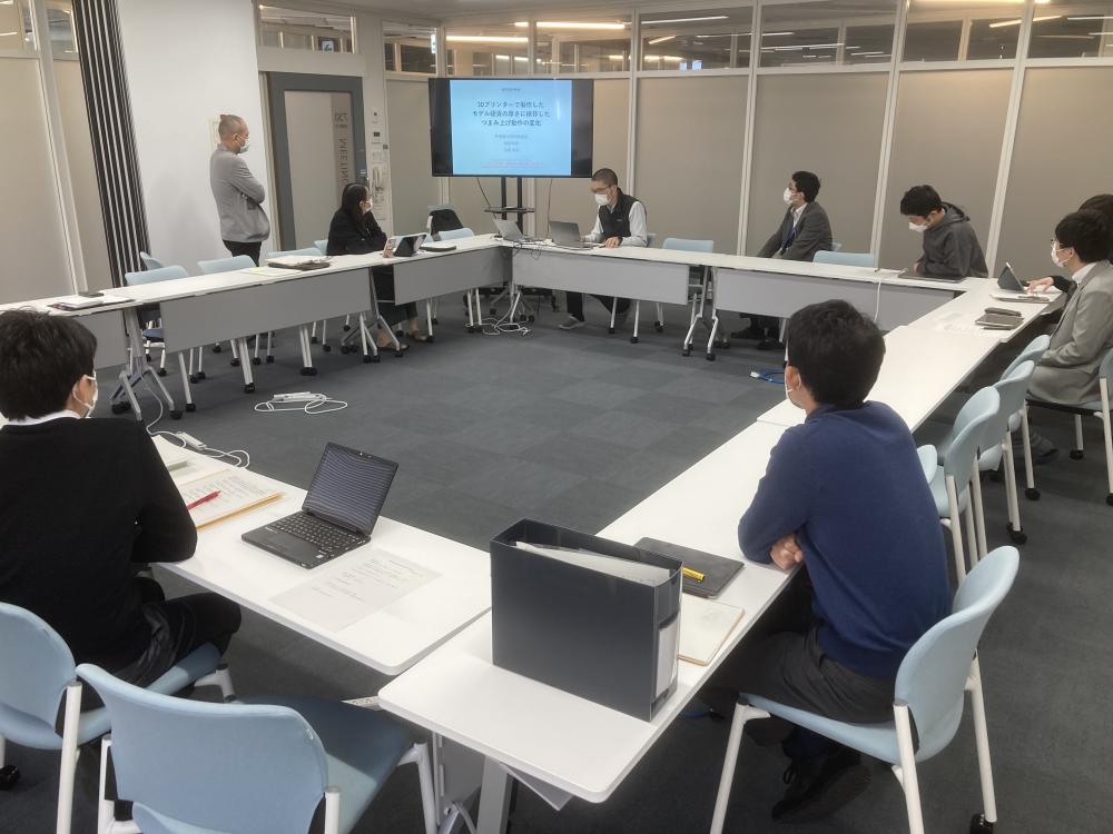 作業療法学科の定期教員勉強会の様子。参加者がテーブルを囲み、プレゼンテーションを聴いている。