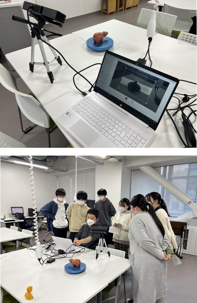 3Dスキャナ体験会の様子。テーブル上にスキャナとノートパソコンがあり、参加者が興味深く見守っている。