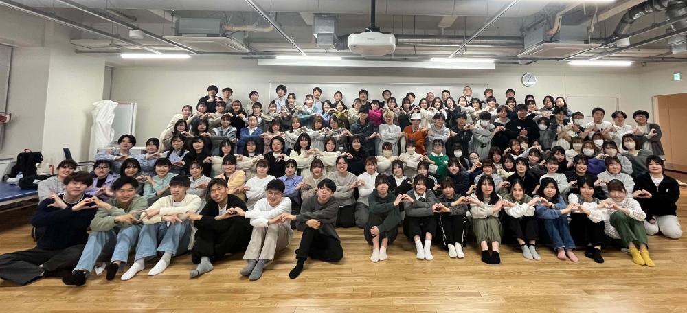 作業療法学科の新入生歓迎会での集合写真、学生たちが笑顔でポーズをとっている。