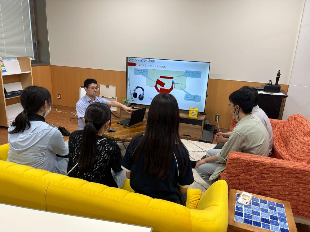 医療に関するプレゼンテーションを受ける学生たちと講師が映る会議室の様子。