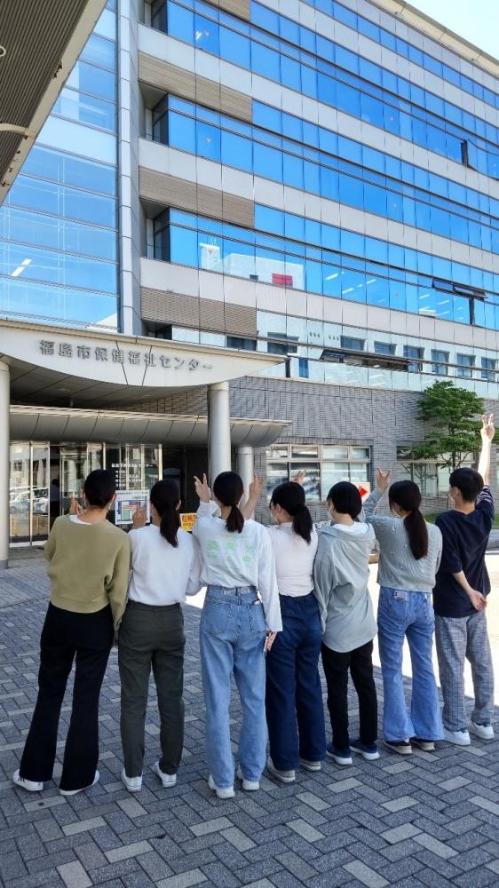 福島市こども発達支援センターの前で、理学療法学科の学生たちが並んでいる様子。