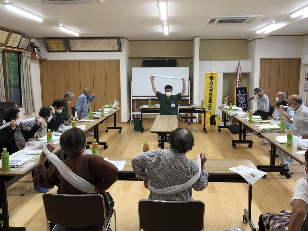 理学療法学科の教員が出前講義を行い、参加者が体操をしている様子。