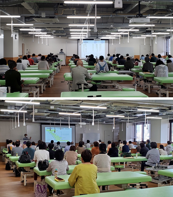 模擬患者養成講座の様子。多くの参加者が講義を受けている教室の風景。