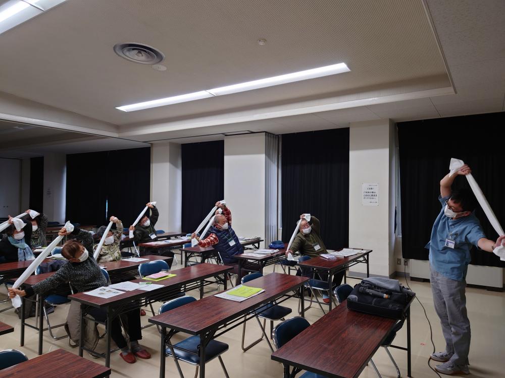 理学療法学科の教員が講演中、受講生たちがストレッチを行っている様子。
