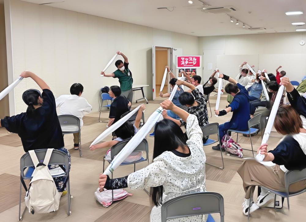 理学療法学科の教員が参加者に向けてストレッチの指導を行っている様子。