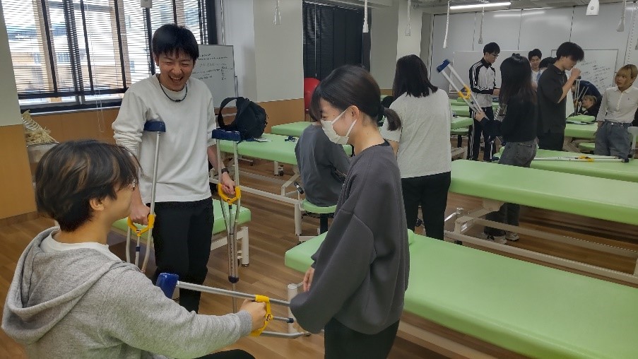 臨床実習に向けた学内演習で、学生たちが器具を使って相互に支援し合っている様子。