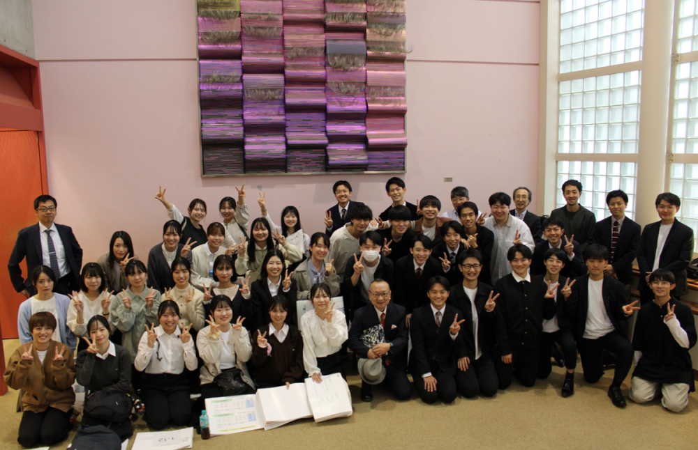 理学療法学科の学生たちがポスター発表後に集合し、笑顔でピースサインをしている写真。