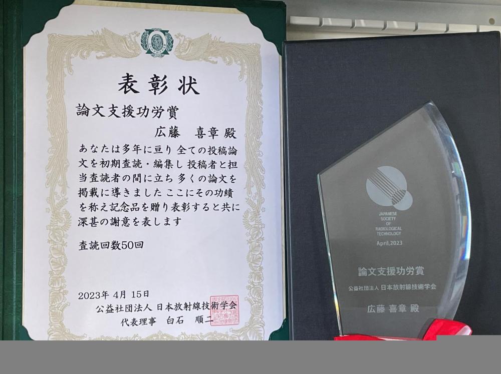 診療放射線科学科教員が受賞した論文支援功労賞の表彰状とトロフィーの画像。