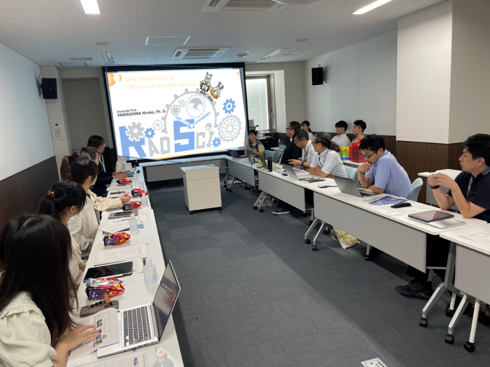 中臺科技大學の教員と学生が福島県立医科大学で研究交流を行い、プレゼンテーションを聴いている様子。