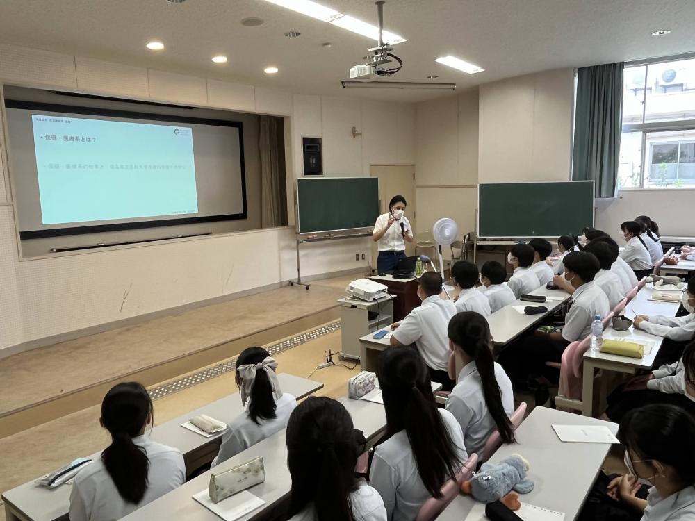高校生への講演が行われている教室の様子。講師がスライドを使って説明し、生徒たちが熱心に聴いている。