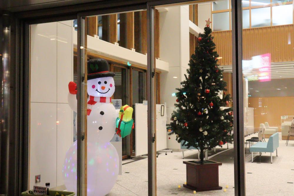 クリスマスの飾り付けが施された室内に、雪だるまとクリスマスツリーが飾られている様子。