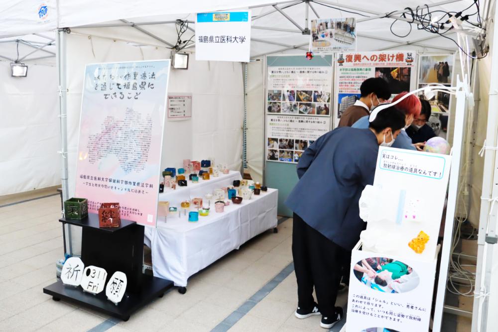 福島県立医科大学のブースで、参加者が展示物を見学している様子。