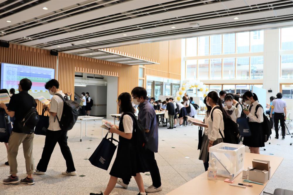 保健科学部オープンキャンパス2023の会場で、参加者が説明を受けながら移動している様子。