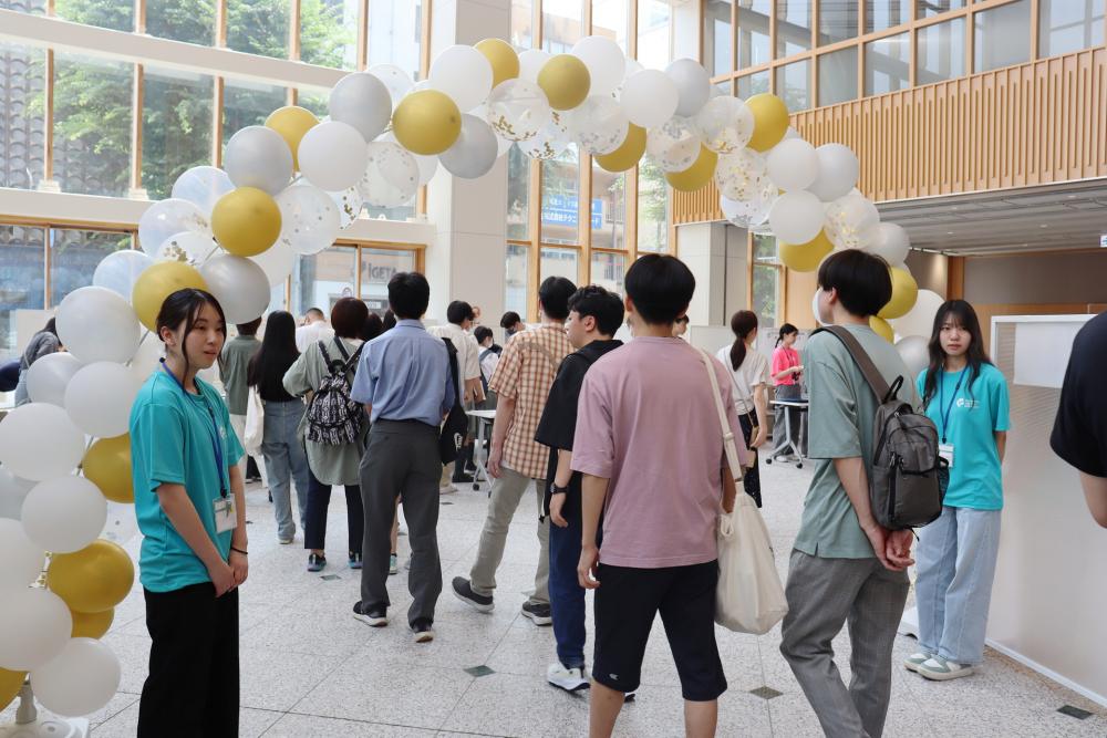 保健科学部オープンキャンパス2024の会場で、参加者がバルーンアーチの下を通りながら交流している様子。