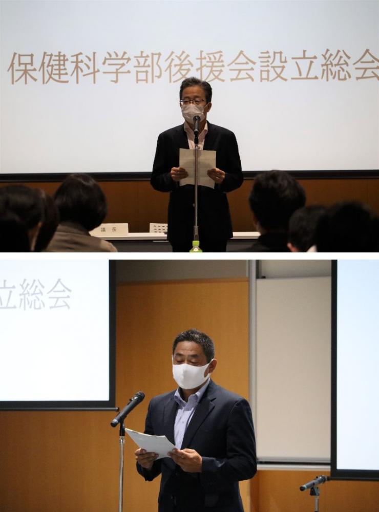 保健科学部後援会設立総会でスピーチをする二人の男性。背景には「保健科学部後援会設立総会」の文字が表示されている。