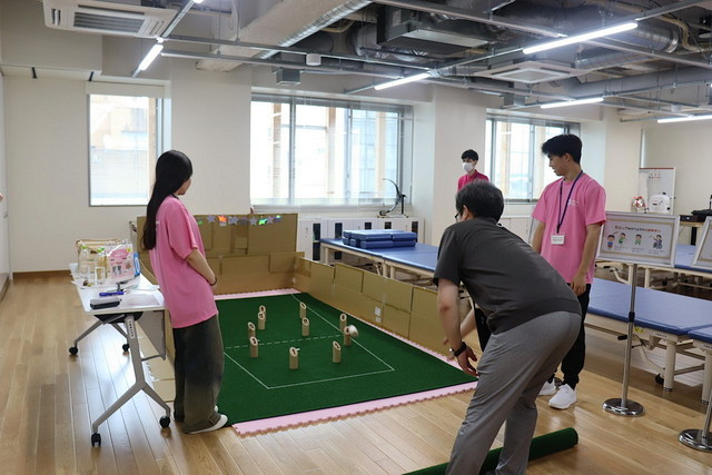 保健科学部オープンキャンパス2024の受付風景、参加者が資料を受け取る様子。