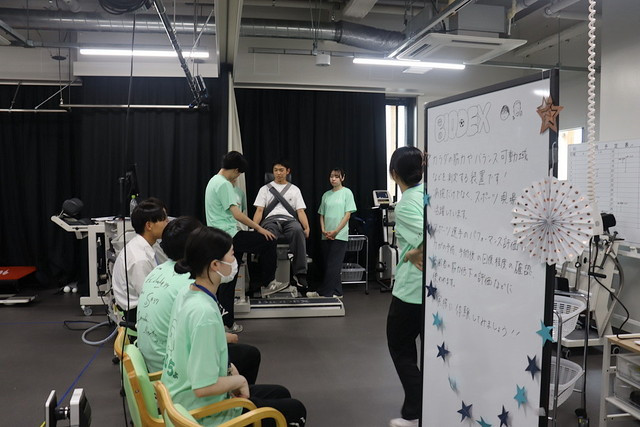 保健科学部オープンキャンパス2024の会場で、参加者がバルーンアーチの下を通りながら交流している様子。