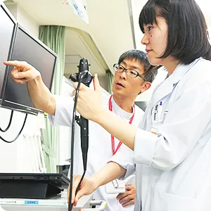 医療人育成・支援センターでの教育風景。医師が学生に内視鏡の操作を指導している様子。