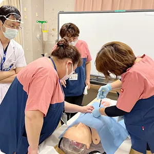 看護師特定行為研修の実習中、参加者がシミュレーターを使って技術を学んでいる様子。