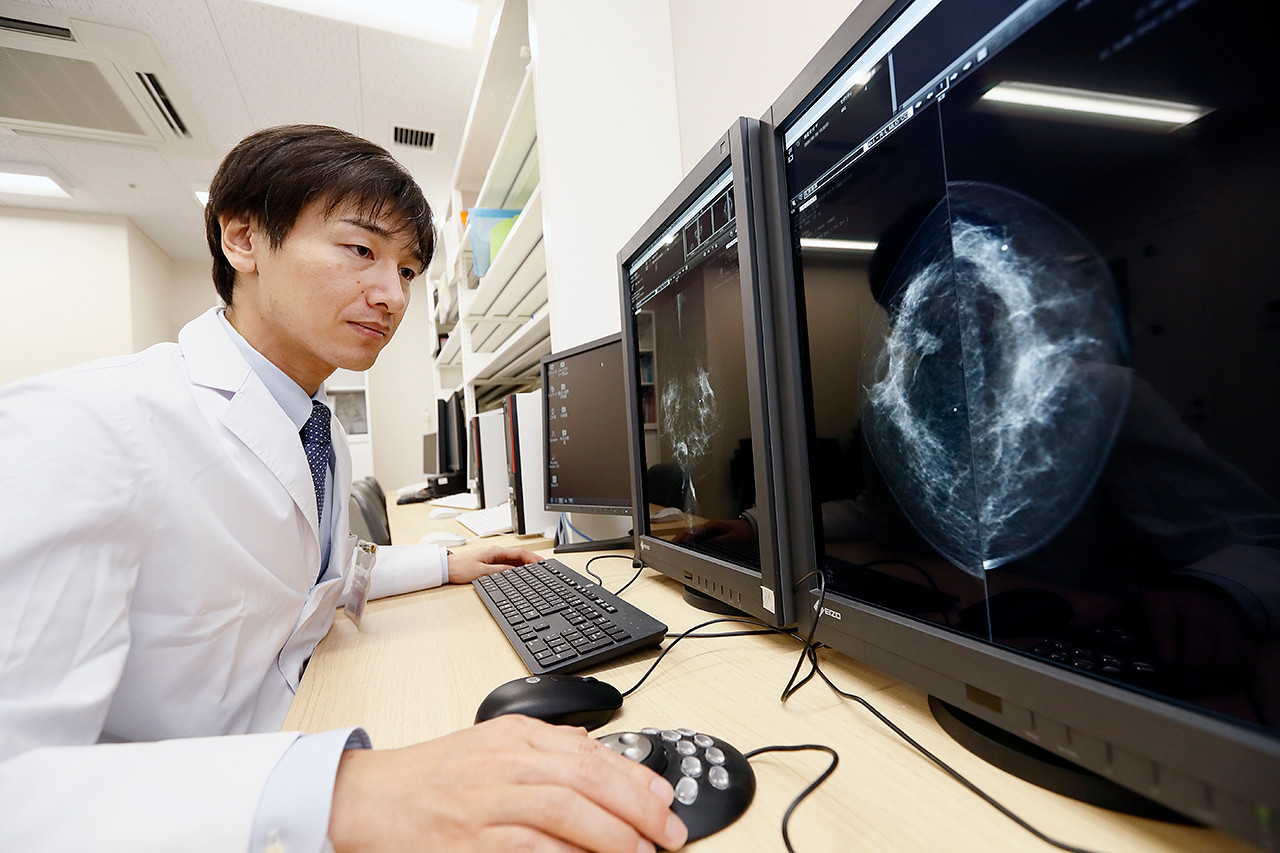 医師がコンピュータで乳房の画像を解析している様子。研究や診断に取り組む医療現場の一コマ。
