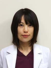 病院助手の菅原由紀子さんが白衣を着て微笑んでいるポートレート。専門分野は循環器内科。