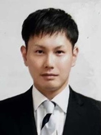 専攻医の猪股佳幸さんがスーツを着て正面を向いているポートレート。