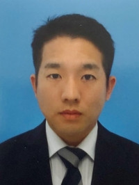 大学院生の鈴木喜敬さんのプロフィール写真。青い背景の前でスーツを着た真剣な表情。