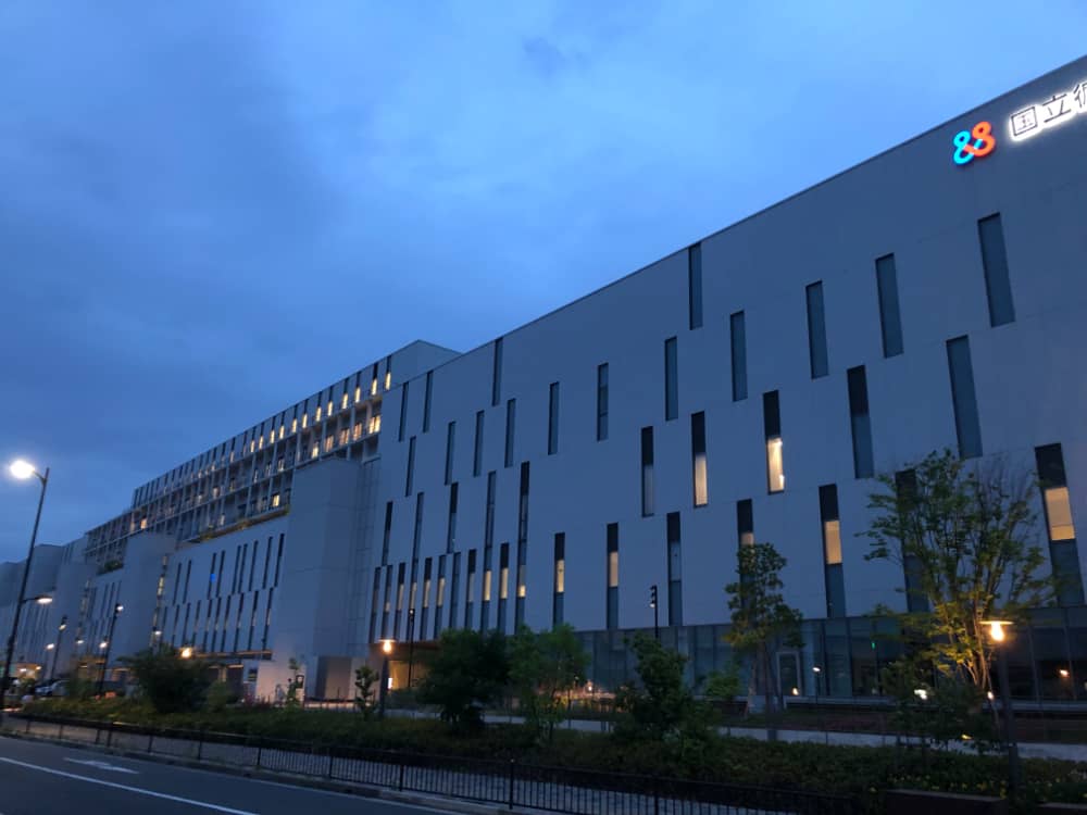 福島県立医科大学の建物が夕暮れ時に照明で照らされている様子。