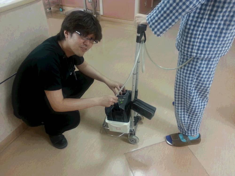医療現場で作業をするスタッフが、患者の補助人工心臓装置を調整している様子。