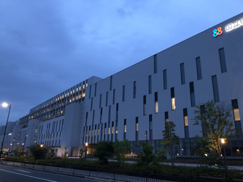 福島県立医科大学の建物が夕暮れ時に照明で照らされている様子。