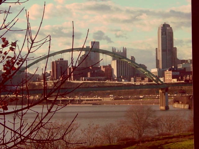 川にかかる大きなアーチ型の橋と、高層ビル群の景色