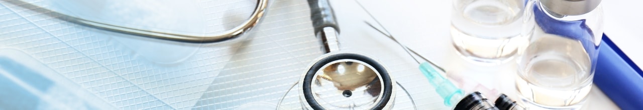 聴診器、注射器、薬瓶が並べられた医療設備のクローズアップ。医療現場を連想させる配置。