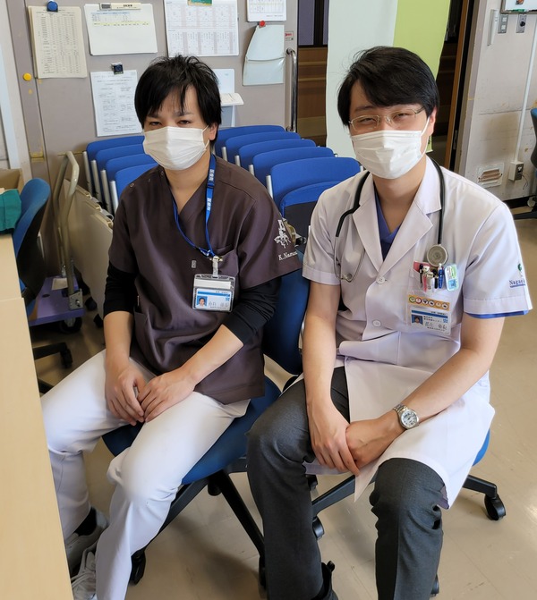 研修医の長江先生と野村先生がマスクを着用し、病院の待機室で座っている様子。