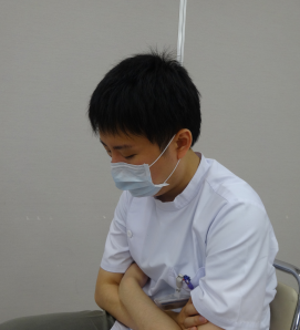 医療現場でマスクを着用し、考え込むスタッフの姿。