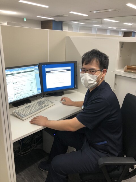 医療現場で働く齋藤悠さんがデスクでパソコンを操作している様子。